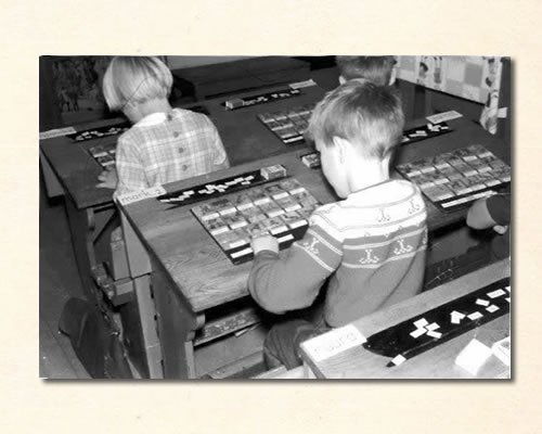 jongentje_met_leesplankje_op_tafel_1963