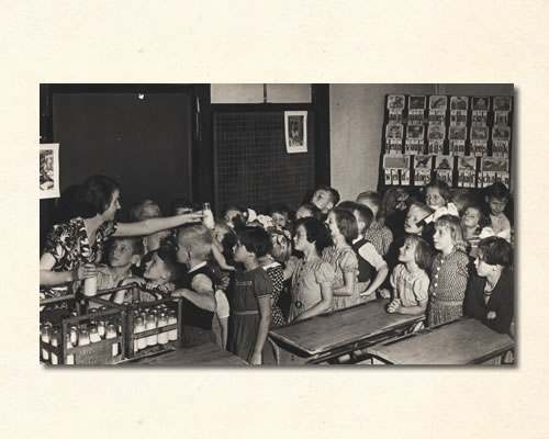 schoolmelk wordt uitgedeeld met klassikale leesplank achter in klas